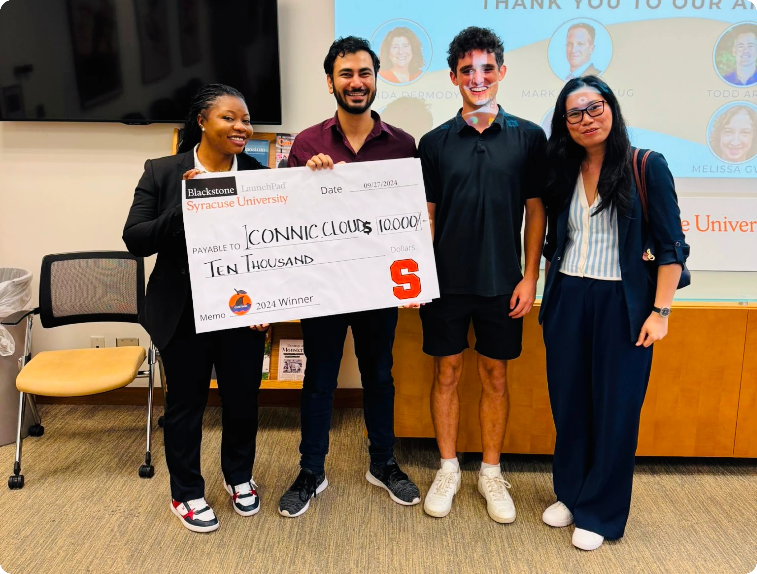 Four people holding a check with a website design company's logo