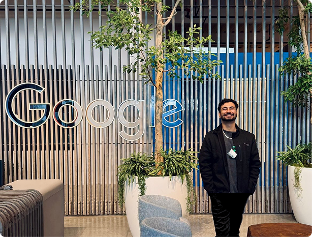 A man standing in front of a wall with the word 'Google' and a tree in a pot, with a corporate and business website design